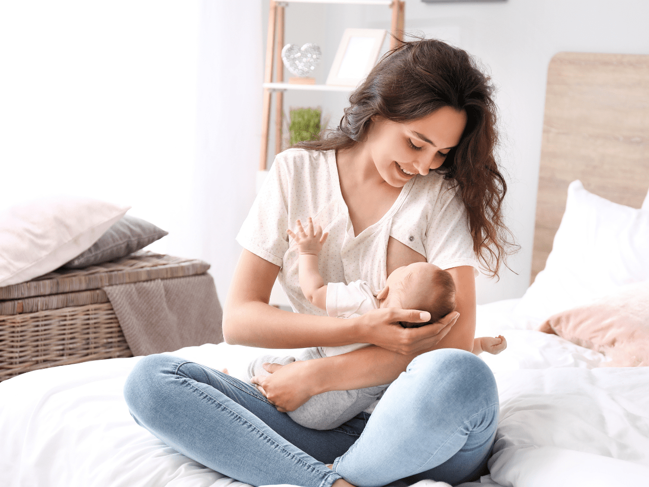 Mamá lactando a su bebé con una sonrisa tranquila en su cama, representando la calma y seguridad que puede lograr con el curso sobre mitos de alimentación en lactancia.