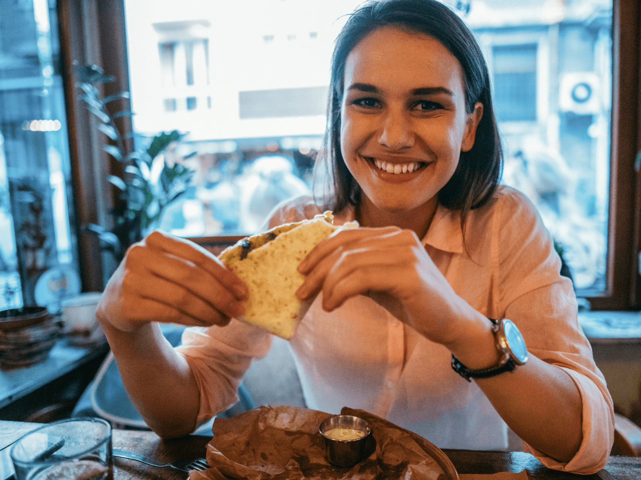Mujer sonriente y relajada, reflejando bienestar y confianza después de aprender a comer fuera sin miedo ni angustia.