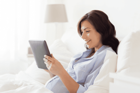 embarazada-relajada-tablet-nutricion-embarazo-sin-miedo.jpg Embarazada relajada viendo una tablet, representando claridad y tranquilidad para tomar decisiones de nutrición seguras durante el embarazo.