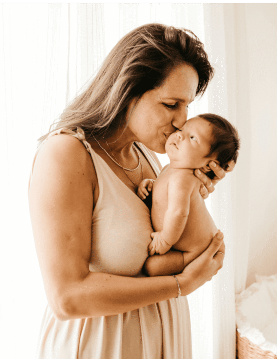 postparto-mama-bebe-beso-bienestar-nutre-tu-postparto.jpg Mamá en casa con su bebé, representando calma y acompañamiento en nutrición postparto y lactancia sin miedo.